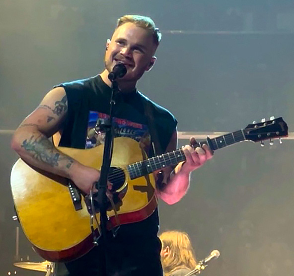 Zach Bryan singing on stage