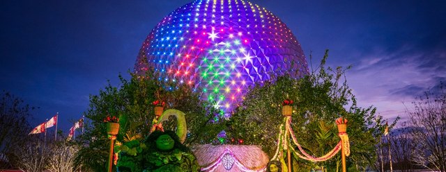 The Epcot Spaceship Earth sphere lit in blue and purple after dark
