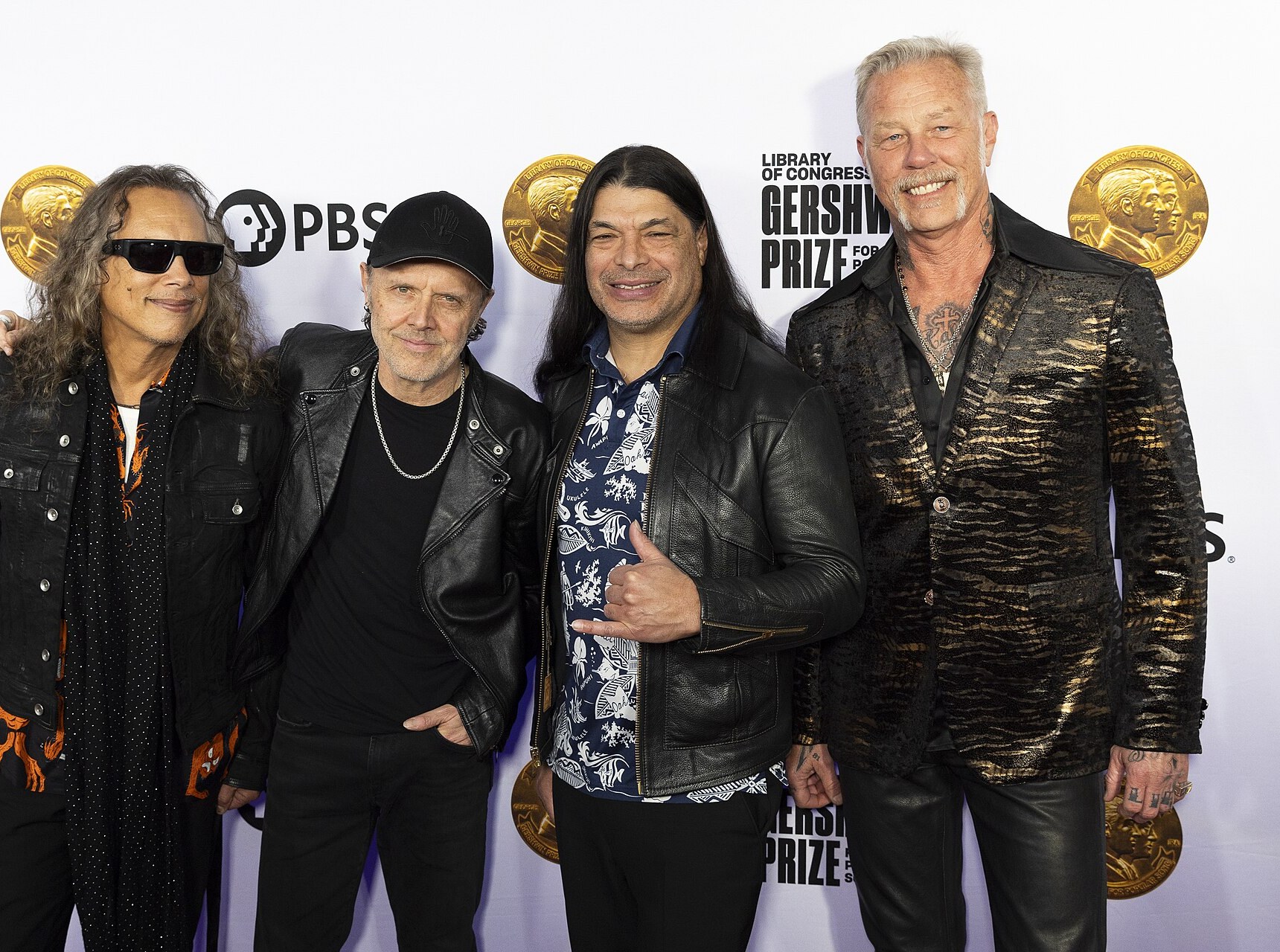 Metallica posing together on a red carpet