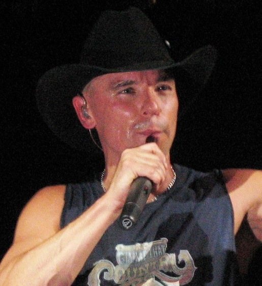Kenny Chesney singing in a black cowboy hat