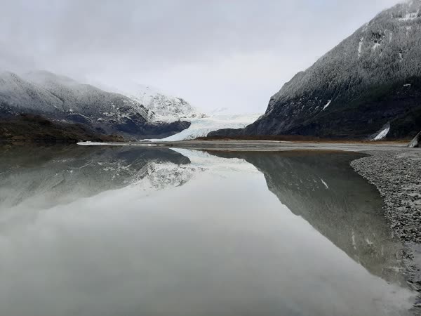 Mendenhall Glacier near Juneau, Alaska, blue ice meeting a still lake below forested ridges