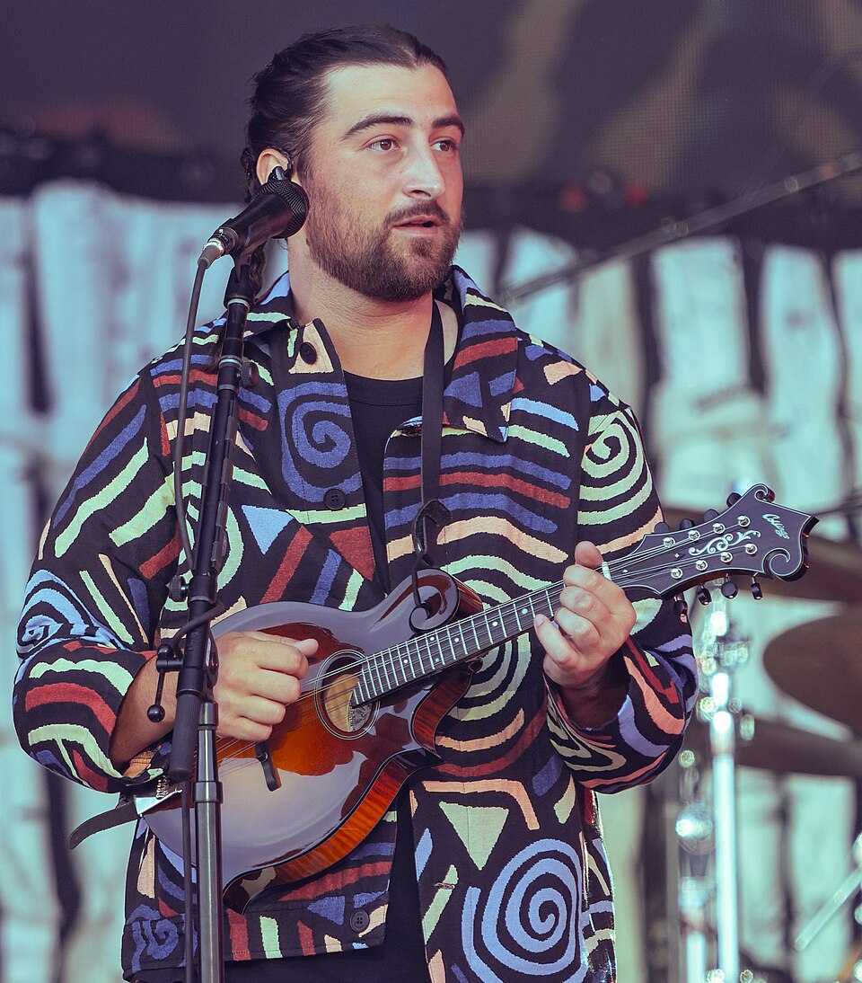 Noah Kahan playing mandolin on stage