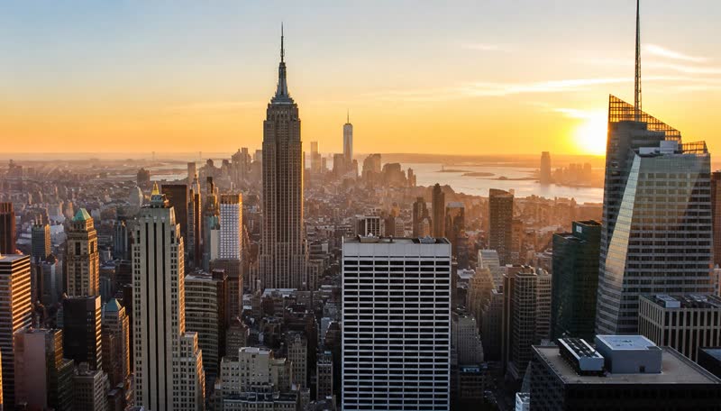 Midtown Manhattan skyscrapers at sunrise with the Empire State Building in golden light
