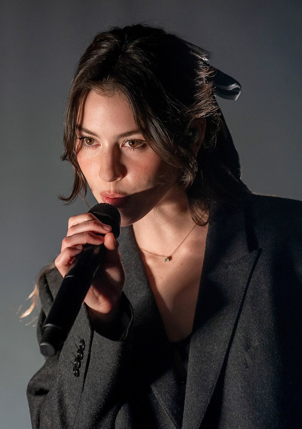 Gracie Abrams singing into a microphone